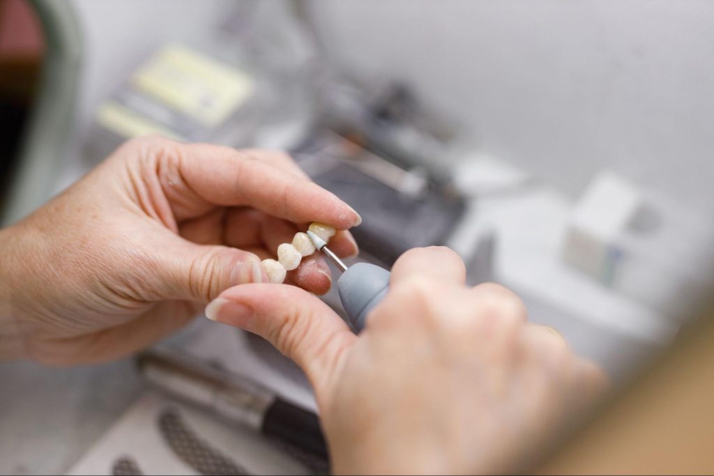 Dental technician working on a dental bridge in a laboratory
